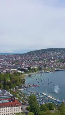 Güneşli günde Zürih Skyline ve Zürih Gölü. İsviçre. Hava görüntüsü. Drone geriye doğru hareket ediyor. Dikey Video