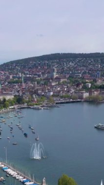 Güneşli günde Zürih Skyline ve Zürih Gölü. İsviçre. Hava görüntüsü. İnsansız hava aracı yan yana hareket ediyor. Dikey Video