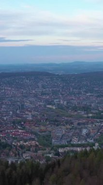 Bulutlu bir günde Uetliberg Dağı 'ndan Zürih Skyline ve Zürih Gölü. İsviçre. Hava görüntüsü. İnsansız hava aracı yan yana hareket ediyor. Dikey Video