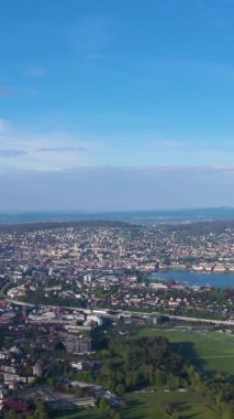 Güneşli bir günde Uetliberg Dağı 'ndan Zürih Skyline ve Zürih Gölü. İsviçre. Hava görüntüsü. Drone ileri gidiyor. Dikey Video