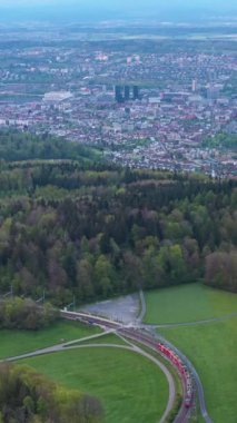 Uetliberg Dağı 'na giden tren. Zürih Skyline. İsviçre. Hava görüntüsü. Drone ileri gidiyor. Dikey Video