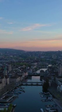 Zürih Skyline ve Sunrise 'daki Old Town. Limmat Nehri. Altın Saat. İsviçre. Hava görüntüsü. Yörüngede. Dikey Video