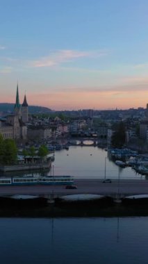 Zürih City Eski Şehir Skyline ve Limmat River Sunrise 'da. Altın Saat. İsviçre. Hava görüntüsü. Drone ileri geri hareket ediyor. Dikey Video