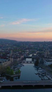 Zürih Şehri Eski Şehir ve Gündoğumunda Limmat Nehri. Altın Saat. İsviçre. Hava görüntüsü. Drone ileri gidiyor. Dikey Video