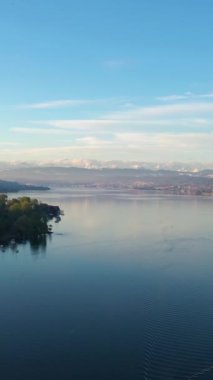 Güneşli bir sabahta Zürih Gölü ve İsviçre Alpleri. Karla kaplı dağlar. İsviçre. Hava görüntüsü. Drone ileri gidiyor. Dikey Video
