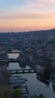Zürih Şehri Eski Şehir ve Gündoğumunda Limmat Nehri. Altın Saat. İsviçre. Hava görüntüsü. Yörüngede. Dikey Video