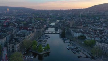 Zürih Şehri Eski Şehir ve Gündoğumunda Limmat Nehri. Altın Saat. İsviçre. Hava görüntüsü. İnsansız hava aracı aşağıya doğru hareket ediyor, yukarı doğru. Turna Vuruşu