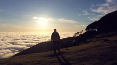 Tepedeki Adam 'ın Silueti Gün Doğumu' na bakıyor. Bulutlar Ters Dönüyor. Hava Aracı Atışı. Madeira, Portekiz. Yörüngede