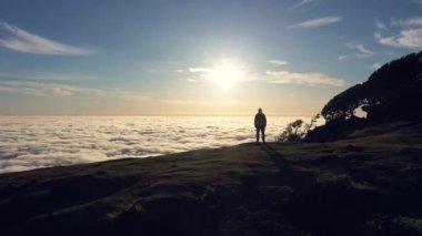 Güneşin doğuşunda Tepedeki Adam 'ın Silueti. Bulutlar Ters Dönüyor. Hava Aracı Atışı. Madeira, Portekiz. İleriye Taşınma