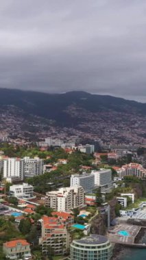 Bulutlu bir günde Funchal City. Oteller ve Atlantik Okyanusu. Madeira, Portekiz. Hava Aracı Atışı. Yörüngede. Dikey Video