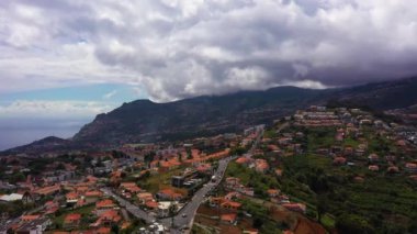 Bulutlu bir günde Funchal Şehri ve Dağları. Dramatik Gökyüzü. Madeira, Portekiz. Hava Aracı Atışı. İleriye Taşınma