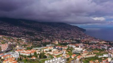 Bulutlu bir günde Funchal Şehri ve Dağları. Kara Fırtınalı Gökyüzü. Madeira, Portekiz. Hava Aracı Atışı. Yukarı Taşıma