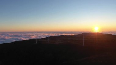Gün batımında Madeira 'daki Dağ Platosu' nda rüzgar türbinleri. Bulut Dönüşümü. Portekiz. Hava Aracı Atışı. İleriye Taşınma
