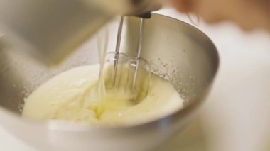 Elektrikli El Karıştırıcı ve İçindekilerle Bir Kasede Yumurta Dökmek. Ağır çekim. Yakın çekim çekim.