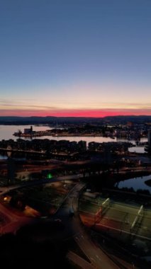 Oslo Şehir Merkezi ve Oslo Fjord, Norveç Yazın Akşam Alacakaranlığı. Mavi Saat. Hava Aracı Atışı. İleriye ve yukarıya doğru ilerliyoruz. Dikey Video