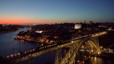 Porto Şehri 'ni, Douro Nehri' ni ve I. Dom Luis Köprüsü 'nü Tram ile aydınlattı. Akşam Alacakaranlığı 'nda Turist Bakış Açısı Miradouro da Serra do Pilar' dan görüntü. Portekiz