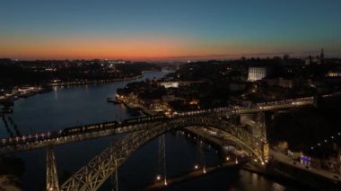 Porto Şehri 'ni, Douro Nehri' ni ve Dom Luis Köprüsü 'nü gece tramvayıyla aydınlattı. Mavi Saat. Portekiz. Hava Aracı Atışı. İleri, Aşağı Eğil