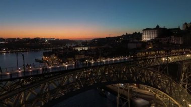 Aydınlatılmış Porto Şehri, Douro Nehri ve Dom Luis Köprüsü I ile Akşam Alacakaranlığı Tramvayı. Mavi Saat. Portekiz. Hava Aracı Atışı. Geriye ve Yukarı Taşıma