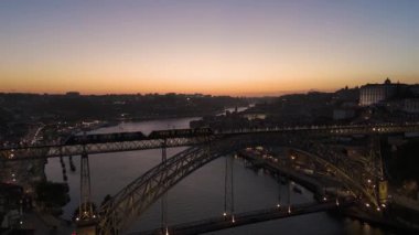Aydınlatılmış Porto Şehri, Douro Nehri ve Dom Luis Köprüsü I ile Akşam Alacakaranlığı Tramvayı. Mavi Saat. Portekiz. Hava Aracı Atışı. Yörüngede