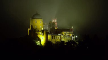 Sintra 'daki Pena Palace' ı gece aydınlatmış. Portekiz. Yuvarlanan Bulutlar, Sis