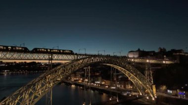 Porto Şehri, Douro Nehri ve Dom Luis Köprüsü 'nü gece tramvayı ile aydınlattı. Mavi Saat, Akşam Alacakaranlığı. Portekiz. Hava Aracı Atışı. Yukarı ve Aşağı Taşıma