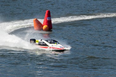 PESO DA REGUA, PORTUGAL - 15 Eylül 2024: Siyah ve beyaz sürat teknesi yarış sırasında su sıçramalarıyla keskin dönüş yaptı. Kırmızı Şamandıra. Formula 2 Dünya Şampiyonası