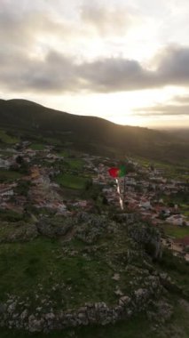 Ulusal Portekiz Bayrağı, Village ve Green Hilly Peyzajı Sunset 'te. Serra de Montejunto Dağları. Hava görüntüsü. İleri, aşağı doğru hareket edin. Dikey Video