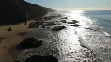 Güneşli bir günde Magoito Sahili ve Kayalıkları. Atlantik Okyanusu, Portekiz. Hava görüntüsü. İlerliyor, Eğiliyor