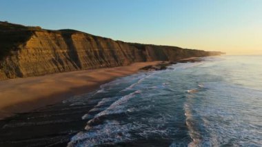 Low Tide sırasında Sunset 'teki Magoito Sahili ve Kayalıkları. Atlantik Okyanusu, Portekiz. Altın Saat. Hava görüntüsü. İleriye Taşınma