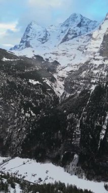 Kışın Eiger ve Monch Dağları. İsviçre Alpleri. İsviçre. Hava görüntüsü. İlerleyin, ilerleyin. Şutu göster. Dikey Video