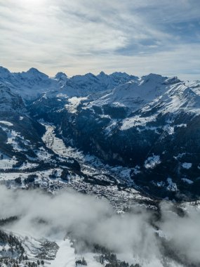 Lauterbrunnen Vadisi ve kışın Karlı Dağlar. İsviçre Alpleri. İsviçre. Bulutlar üzerinde hava görüntüsü. Mannlichen Üst Görünümü