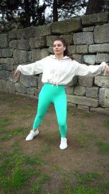 Beyaz Ceketli Genç Güzel Kadın Dansçı Zumba Açık Hava. Tam doz. Dikey Video