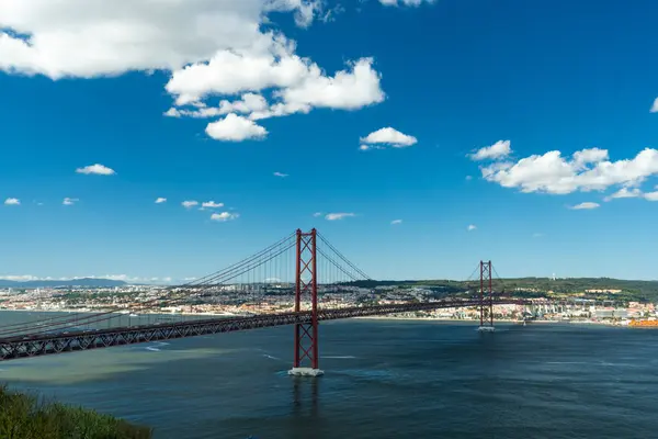 25 Nisan Köprüsü ve Tagus Nehri. Ponte 25 de Abril Askı Köprüsü ve Lisbon Skyline. Mavi Gök ve Kümülüs Pofuduk Bulutları. Portekiz