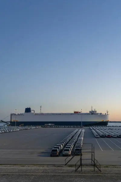 Ro-Ro Kargo Gemisi ve Yeni Arabalar Akşam Alacakaranlığı 'nda Port' taki Büyük Otoparka Dağıtıma Hazır. İhracat ve ithalat için Liman Araba Deposu. Otomobil Endüstrisi. Setubal, Portekiz