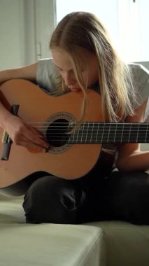 13 yaşında, evde gitar çalan genç bir kız. Dikey Video