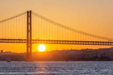 25 Nisan Askı Köprüsü ve Tagus Nehri, Sunset 'te. Lizbon, Portekiz. Cacilhas 'tan görüntü, Almada. Altın Saat