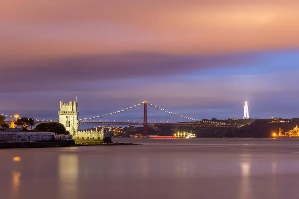 Aydınlatılmış Belem Kulesi, 25 Nisan Askı Köprüsü, Cristo Rei Anıtı ve Tagus Nehri Gece. Lizbon, Portekiz. Mavi Saat