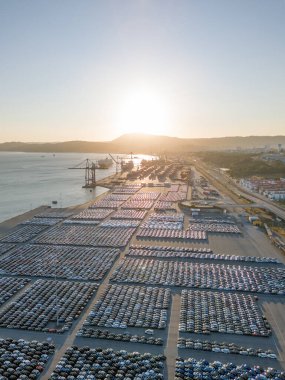 Port Ready 'deki Sunset' te Büyük Otoparktaki Yeni Arabalar Dağıtıma Hazır. Araba Deposu, Otomobil Endüstrisi. Okyanus ve Dağlar. Setubal, Portekiz. Hava Görünümü