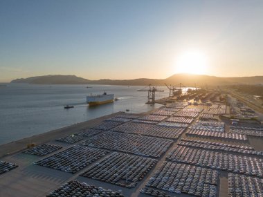 RORO Kargo Gemisi ve Yeni Arabalar Port 'ta Sunset' te Büyük Tam Otopark 'ta Dağıtıma Hazır. Araba Deposu, Otomotiv Endüstrisi. Okyanus ve Dağlar. Setubal, Portekiz. Hava Görünümü