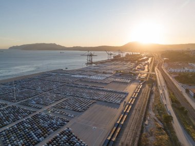 Port Ready 'deki Sunset' te Büyük Otoparktaki Yeni Arabalar Dağıtıma Hazır. Araba Deposu, İthalat ve İhracat. Otomotiv endüstrisi. Atlantik Okyanusu ve Dağları. Setubal, Portekiz. Hava Görünümü