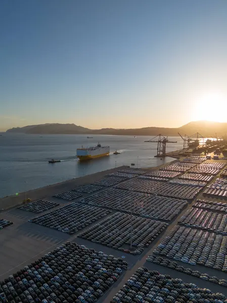 Ro-Ro Kargo Gemisi ve Yeni Otomobillerin Sıraları Port 'ta Sunset' te Büyük Tam Otopark Parkı 'nda dağıtıma hazır. Okyanus ve Dağlar. Setubal, Portekiz. Hava Görünümü
