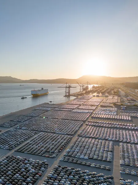 Ro-Ro Kargo Gemisi ve Yeni Otomobillerin Sıraları Port 'ta Sunset' te Büyük Tam Otopark Parkı 'nda dağıtıma hazır. Araba Deposu, Otomobil Endüstrisi. Okyanus ve Dağlar. Setubal, Portekiz. Hava Görünümü