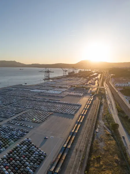 Port Ready 'deki Sunset' te Büyük Otoparktaki Yeni Arabalar Dağıtıma Hazır. Araba Deposu, Otomotiv Endüstrisi. Okyanus ve Dağlar. Setubal, Portekiz. Hava Görünümü