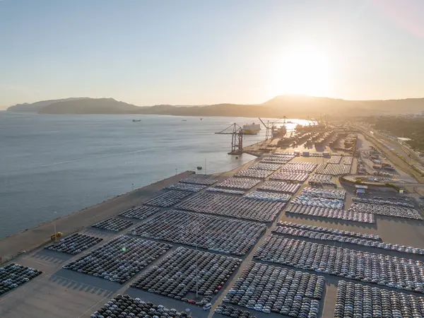 Port Ready 'deki Sunset' te Büyük Otoparktaki Yeni Arabalar Dağıtıma Hazır. Araba Deposu, Otomobil Endüstrisi. Okyanus ve Dağlar. Setubal, Portekiz. Hava Görünümü