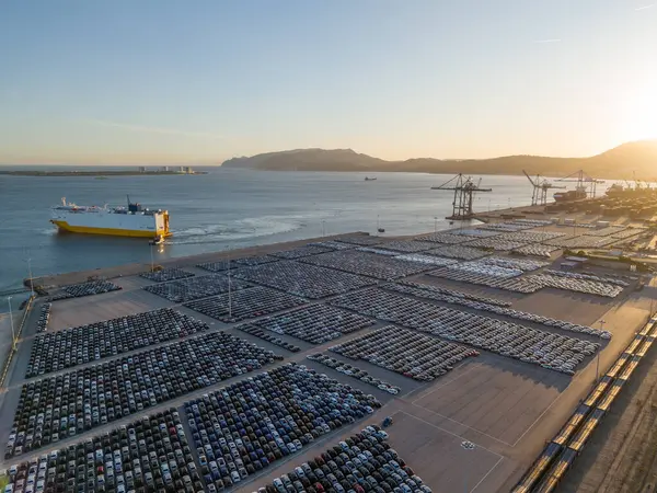 RORO Kargo Gemisi ve Yeni Arabalar Port 'ta Sunset' te Büyük Tam Otopark 'ta Dağıtıma Hazır. Araba Deposu, Otomotiv Endüstrisi. Okyanus ve Dağlar. Setubal, Portekiz. Hava Görünümü