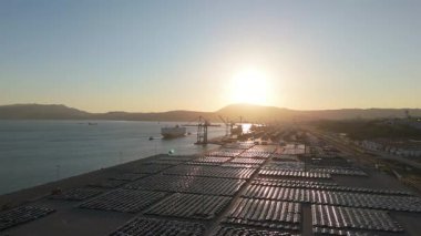 RORO Kargo Gemisi ve Yeni Arabalar Port 'ta Sunset' te Büyük Tam Otopark 'ta Dağıtıma Hazır. Araba Deposu, Otomotiv Endüstrisi. Okyanus ve Dağlar. Setubal, Portekiz. Hava görüntüsü. İleriye Taşınma
