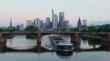FRANKFURT, GERMANY - 11 Haziran 2025: Frankfurt Şehri, Ignatz Bubis Köprüsü Sabah Ana Nehir 'de Tram ve Mavna ile. Hesse, Almanya