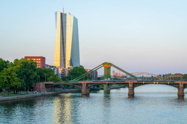 FRANKFURT, GERMANY - 11 Haziran 2025: Frankfurt 'taki Avrupa Merkez Bankası Genel Merkezi ve Sunset' teki Main River 'ın koltuğu. Hesse, Almanya