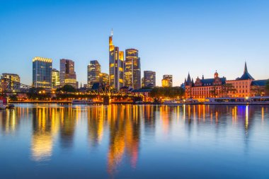 Frankfurt Şehri 'nin merkezindeki gökdelenleri aydınlatmış. Akşam Alacakaranlığı ve Ana Nehir Yansıması' nda. Mavi Saat. Hesse, Almanya