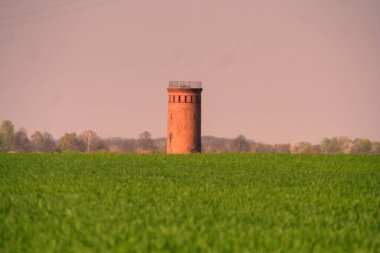 Kırmızı beyaz tuğlalı bir evin kulesi.